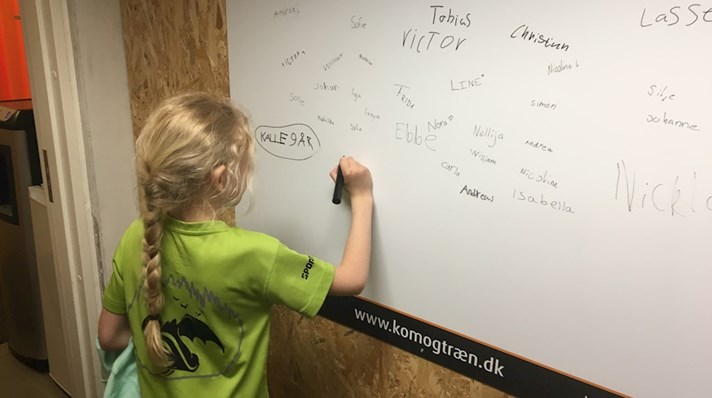 Pige skriver navn på tavle